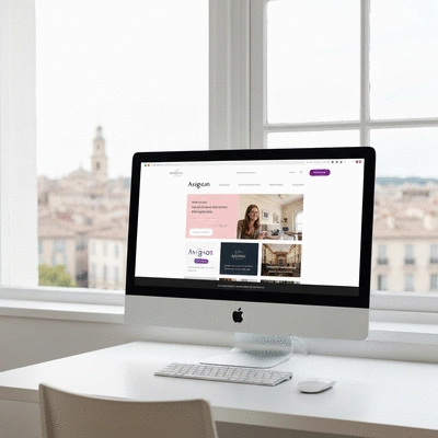 Modern website design on a desktop computer with Avignon cityscape in background